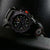 Bracelet de montre pour homme avec boîtier noir, accent orange et chiffres verts lumineux