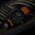 Bracelet de montre pour homme avec bracelet orange et cadran sombre avec détails verts