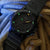 Montre avec cadran noir, index luminescents verts, aiguille jaune et date