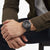 Montre homme au poignet avec cadran noir et bracelet en caoutchouc, portée sur une manche