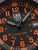 Detailansicht Zifferblatt: schwarze Uhr mit orange Ziffern, Leuchtmarkierungen und Zeigern