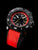 Herrenarmbanduhr schwarz-rot mit runder Lünette, rotem Textilband und Leuchtindizes