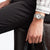 Damenuhr am Handgelenk mit silberfarbenem Mesh-Armband und weißem Zifferblatt