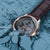 Herrenarmbanduhr mit braunem Lederband und rundem grauem Zifferblatt