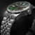 Montre pour homme avec cadran vert, lunette argentée et bracelet en acier inoxydable.