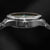 Montre pour homme : vue de dessus sur le boîtier en acier inoxydable avec protège-couronne et lunette.