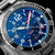 Montre pour homme Marc and Sons avec cadran bleu, aiguilles rouges et boîtier en acier.