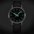 Montre Mondaine Stop2Go avec cadran noir et accents vert/orange, bracelet en cuir noir