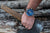 Montre pour homme au poignet avec cadran bleu et bracelet marron.