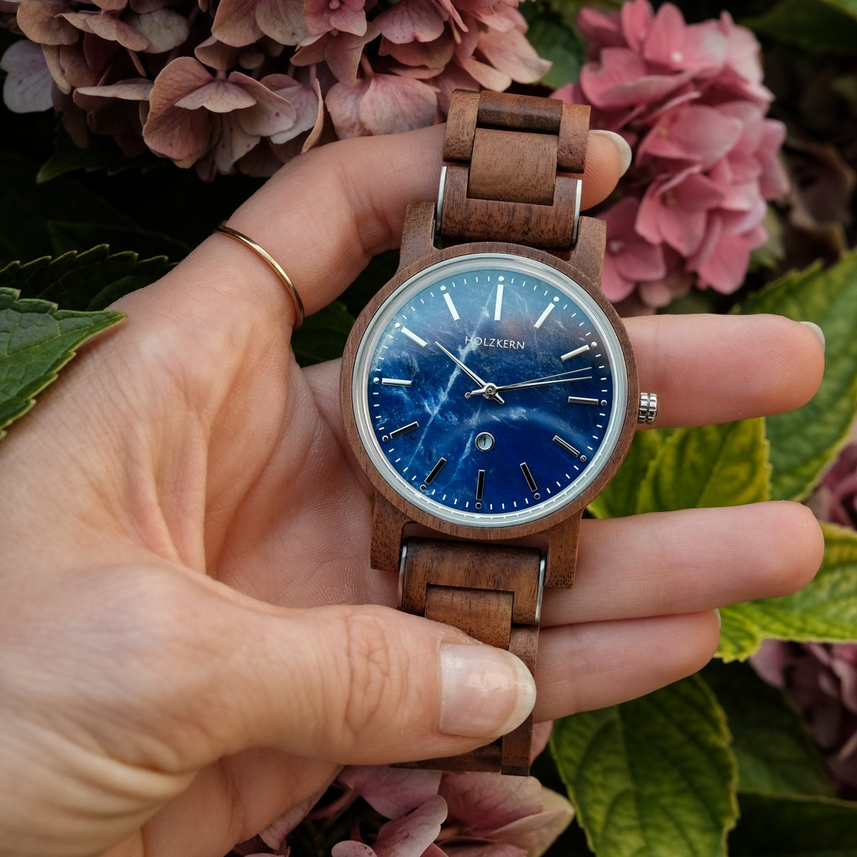 Holzkern Armbanduhr am Handgelenk: blaues Zifferblatt, braunes Holzarmband