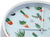 Vue de face d'une horloge murale : cadran bleu clair avec motif cactus, aiguilles blanches