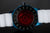 Dos d'une montre bracelet pour homme : lunette noire avec insert rouge et bracelet blanc