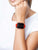 Montre connectée avec bracelet rouge au poignet, écran carré avec cadran