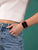 Montre connectée avec bracelet rouge au poignet, écran carré noir