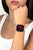 Montre connectée au poignet avec bracelet rose et écran noir, chiffres sur l'écran