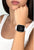 Montre connectée au poignet : écran noir, bracelet blanc avec cadre en strass
