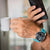 Montre connectée Festina pour homme au poignet, bracelet turquoise avec cadran noir.
