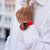 Montre connectée homme au poignet : bracelet en silicone rouge, cadran noir, boîtier argenté