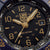Gros plan du cadran : montre pour homme avec aiguilles dorées, guichet de date, index luminescents et « 200 Meters ».
