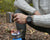 Montre bracelet pour homme au poignet avec bracelet noir et index lumineux sur le cadran