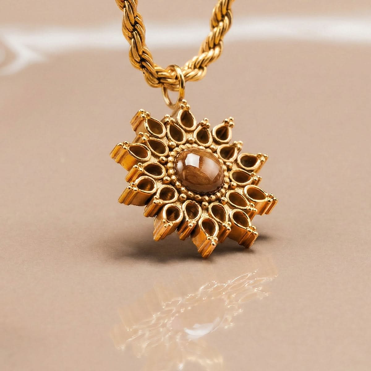 Collier avec chaîne à maillons dorés et pendentif en forme de soleil avec pierre marron