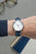 Sternglas Damenuhr am Handgelenk mit blauem Lederarmband und weißem Zifferblatt