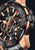 Festina Herren-Chronograph Nahansicht: schwarzes Zifferblatt, orange Markierungen, Roségold-Lünette