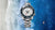 Herrenarmbanduhr mit weißem Zifferblatt, blauer Taucherlünette und Stahlband