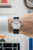 Sternglas Naos Edition Bauhaus X Armbanduhr am Handgelenk, schwarzes Lederband, weißes Zifferblatt