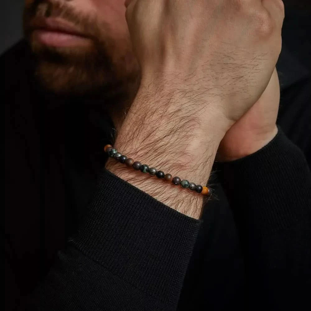 Bracelet avec perles de pierres précieuses sombres et fermoir en acier inoxydable gris au poignet
