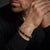 Bracelet avec perles de pierre au poignet, fermoir gris en acier inoxydable bien visible