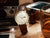 Montre unisexe avec cadran beige et bracelet en cuir marron, aiguilles bien visibles