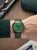 Montre pour homme au poignet : cadran vert, bracelet en cuir vert, boîtier couleur or rose.