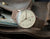Montre homme avec cadran beige, bracelet en cuir marron et boîtier plaqué or rose.