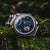 Herrenuhr mit silbernem Edelstahlgehäuse, blauem Zifferblatt und offenem Automatikwerk