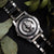 Herrenuhr-Rückseite mit sichtbarem Automatikwerk, silbernem Gehäuse und schwarzem Armband