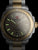 Herrenarmbanduhr mit dunklem Zifferblatt, goldene Zeiger, grün leuchtende Indizes