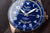 Montre bracelet pour homme, gros plan : cadran bleu avec texte automatique et bracelet en cuir marron