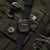 Montre homme avec cadran sombre, accents orange et bracelet textile avec boucle