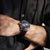 Bracelet de montre pour homme au poignet avec cadran bleu, bracelet en cuir marron et couronne