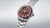 Seiko Herrenuhr mit rotem Zifferblatt, schwarzem Rand an der Lünette und Edelstahlband