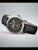 Seiko Herrenarmbanduhr im Seitenblick, silbernes Gehäuse, schwarzes Zifferblatt, Lederarmband