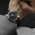 Montre Seiko Presage pour homme au poignet, cadran vert foncé, bracelet en cuir marron.
