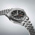 Herrenuhr am Edelstahlarmband, schwarzes Zifferblatt mit roten GMT-Akzenten
