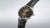 Montre homme avec bracelet en cuir noir et cadran rayonné doré, couronne latérale