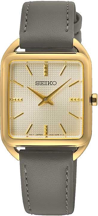 Montre pour femme avec boîtier rectangulaire doré, cadran blanc et bracelet en cuir gris.