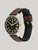 Automatikuhr schräg: schwarzes Zifferblatt, goldene Lünette, braunes Lederarmband