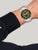 Herrenarmbanduhr am Handgelenk: silbernes Edelstahlband, grünes Zifferblatt, schwarze Lünette