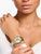 Damenarmbanduhr am Handgelenk mit Blumen-Zifferblatt und Metallband Gold/Silber
