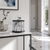 Horloge de table avec cloche en verre et cadran blanc sur socle en pierre claire